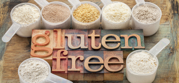 measuring scoops of gluten free flours (almond, coconut, teff, flaxseed meal, whole rice, brown rice, buckwheat) with a text in letterpress wood type