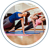 3 women doing an exercise called a side plank push up with an arm sweep- a push up that ends with the person holding themselves u on one arm while the other arm is extended upwards.