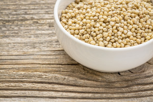 Sorghum in a white bowl, on a wooden table