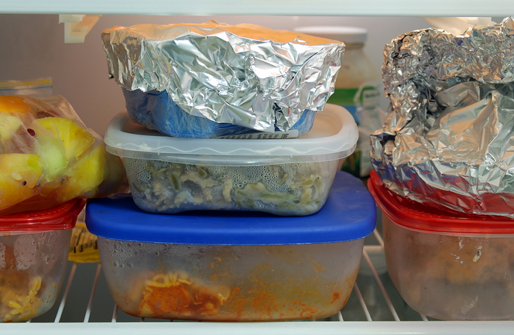 leftover food in plastic and tuperware containers, in the fridge