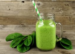 Green smoothie with spinach on wood